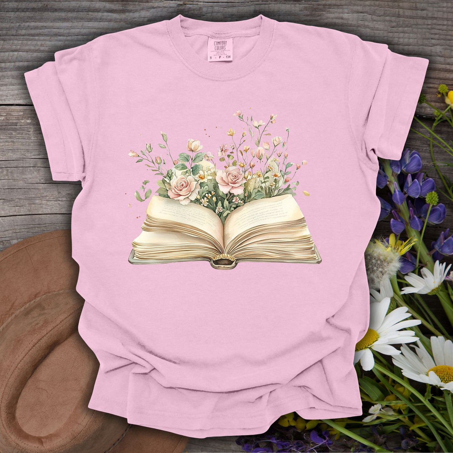 Pink S-sized Blooming Pages t-shirt with an open book overflowing with watercolor roses and wildflowers.