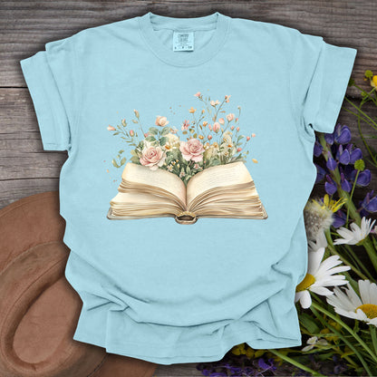 Chambray S t-shirt with a watercolor illustration of an open book blooming with pink roses and wildflowers.