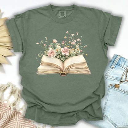 Moss green S-sized t-shirt with a watercolor illustration of an open book overflowing with pink roses and wildflowers.