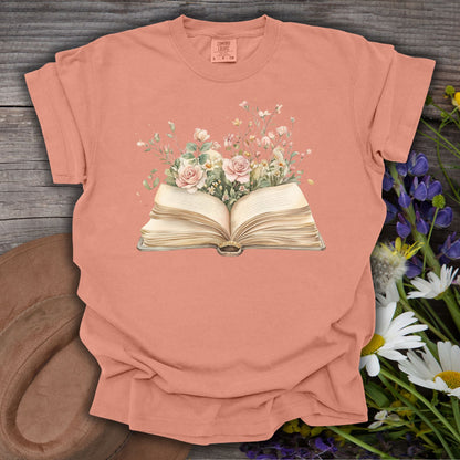Terracotta S t-shirt with a watercolor illustration of an open book overflowing with pink roses and wildflowers.