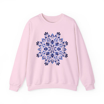 Pink crewneck sweatshirt with a large blue floral folk art snowflake design at the center.