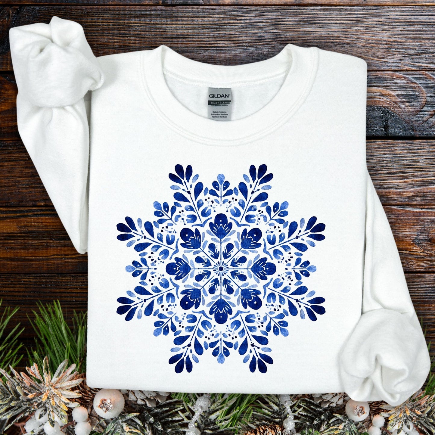 White Gildan crewneck sweatshirt with a large blue folk art floral snowflake design.