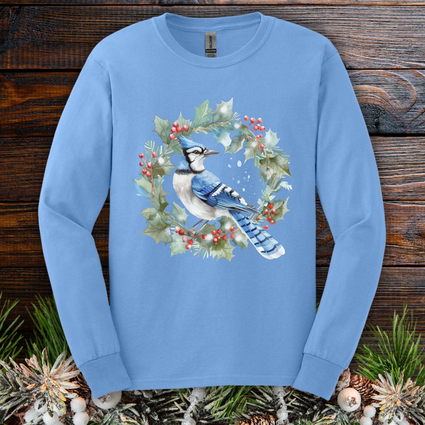 Carolina Blue long sleeve tee with a watercolor blue jay in a holly wreath design.