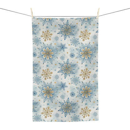 Microfiber tea towel with blue and gold snowflake pattern, hanging from a clothesline.