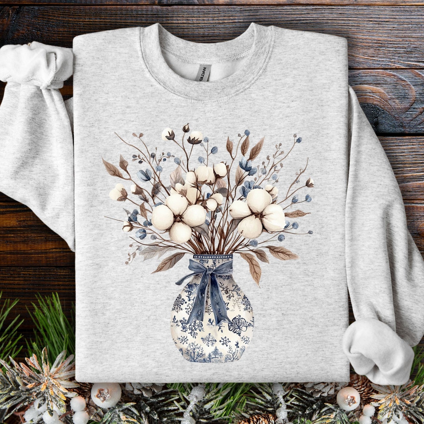 Ash S sweatshirt with a blue and white chinoiserie vase holding a winter bouquet of cotton bolls and dried leaves.