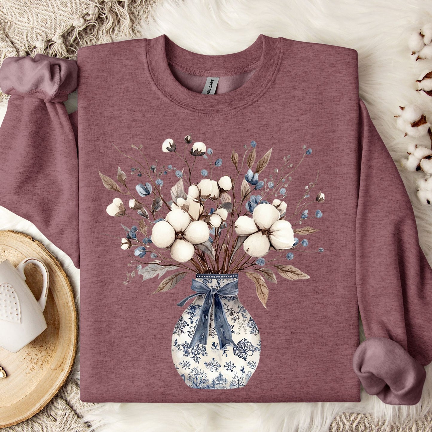 Heather Sport Dark Maroon sweatshirt with a blue and white chinoiserie vase holding a winter bouquet of cotton bolls and dried leaves.