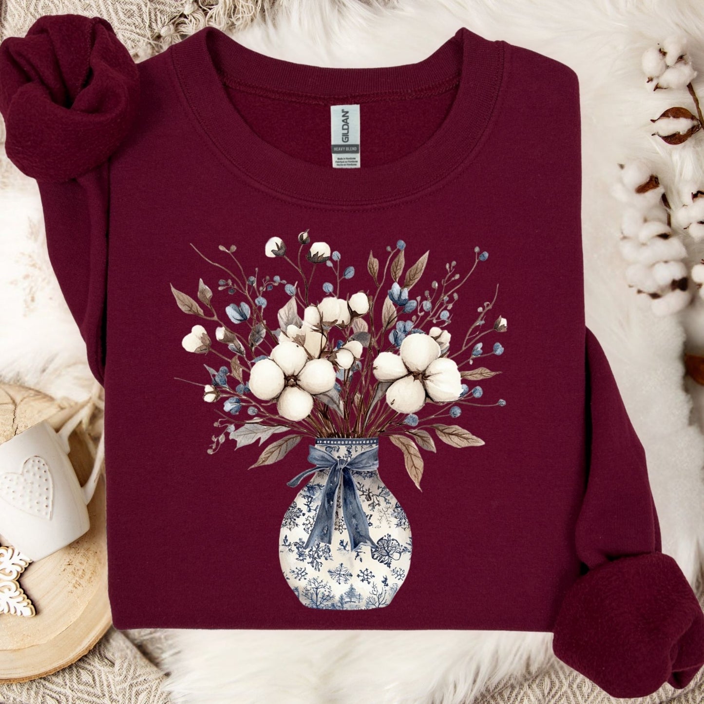 Maroon sweatshirt with a blue and white chinoiserie vase holding a winter bouquet of cotton bolls and berries.