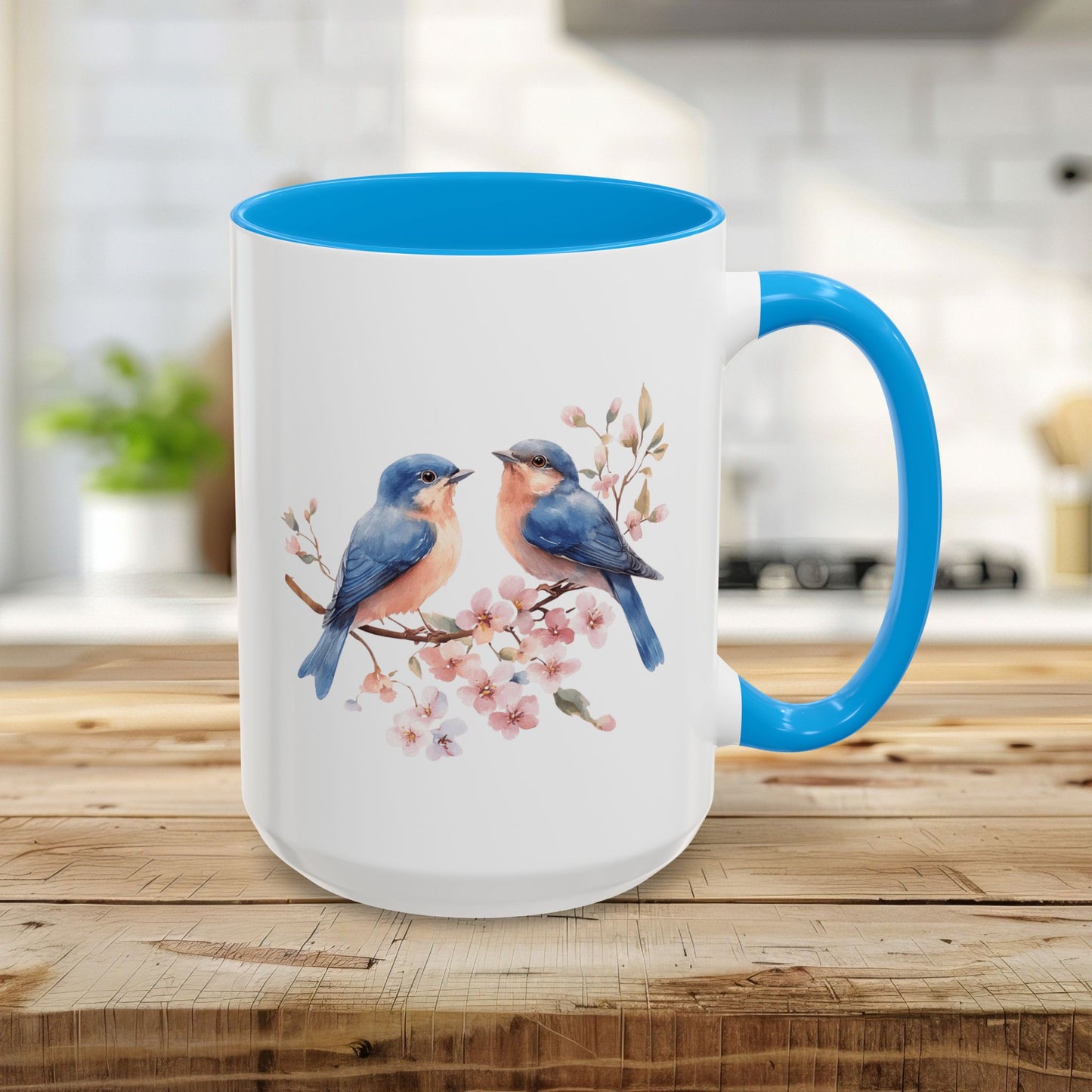 15oz ceramic mug with watercolor bluebirds on cherry blossoms, light blue interior and C-handle.