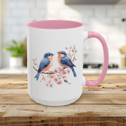 15oz ceramic mug with watercolor bluebirds on cherry blossoms, pink interior and handle.