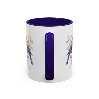 White ceramic mug with bluebirds on cherry blossoms, purple interior and handle.