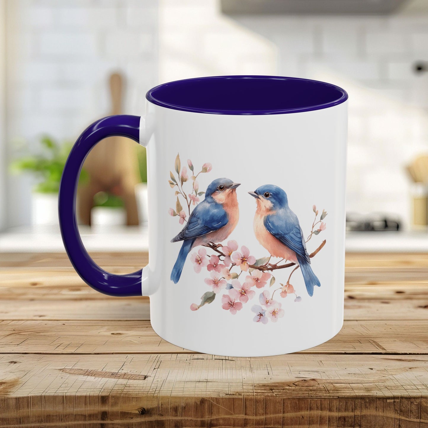 White ceramic mug with bluebirds on cherry blossoms, deep purple interior and C-shaped handle.