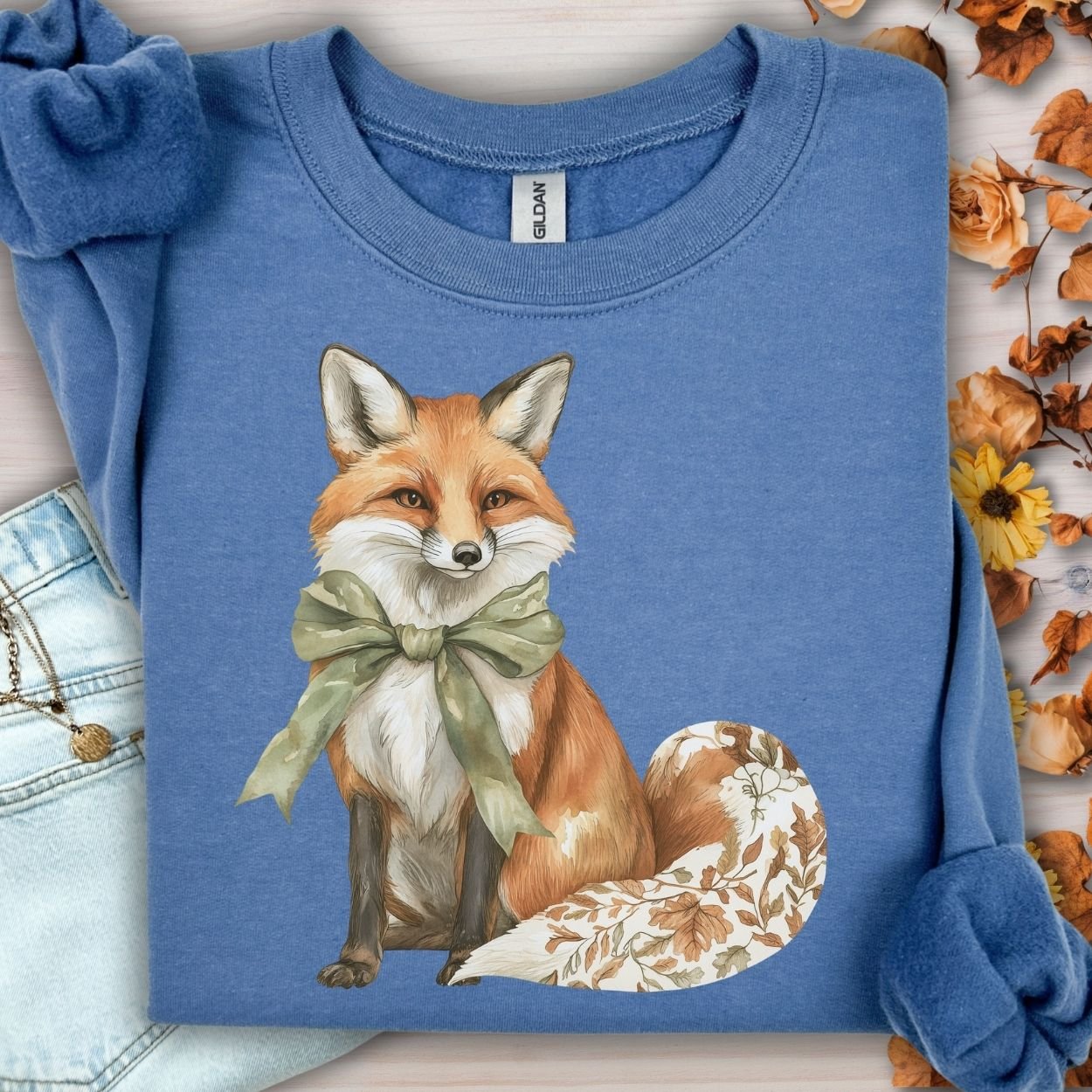 Indigo Blue Gildan sweatshirt with a fox wearing a green bow and a tail with fall botanicals.