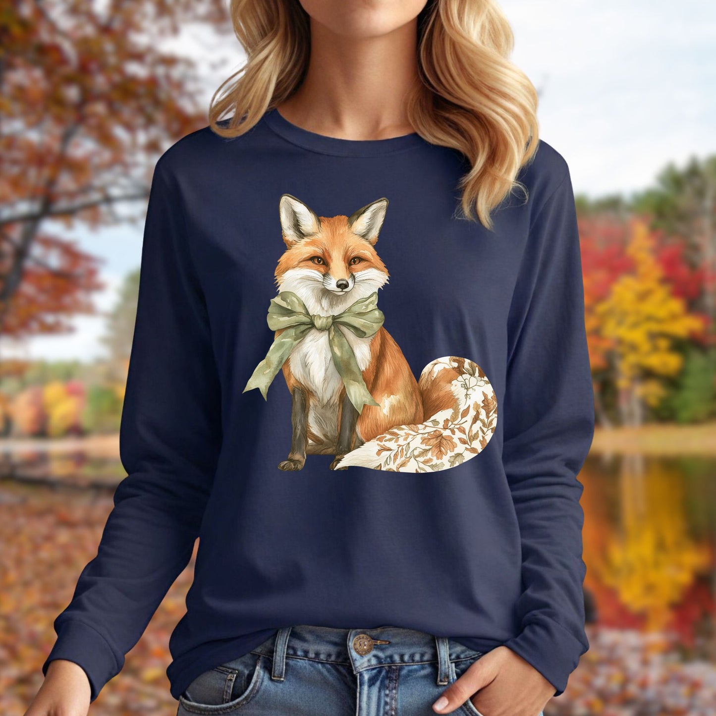 Navy long sleeve tee with watercolor fox wearing a green bow and autumn botanicals on its tail.