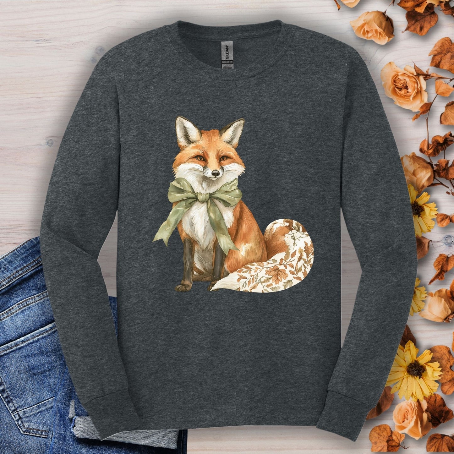 Dark Heather long sleeve tee with a watercolor fox wearing a green bow and autumn botanicals on its tail.