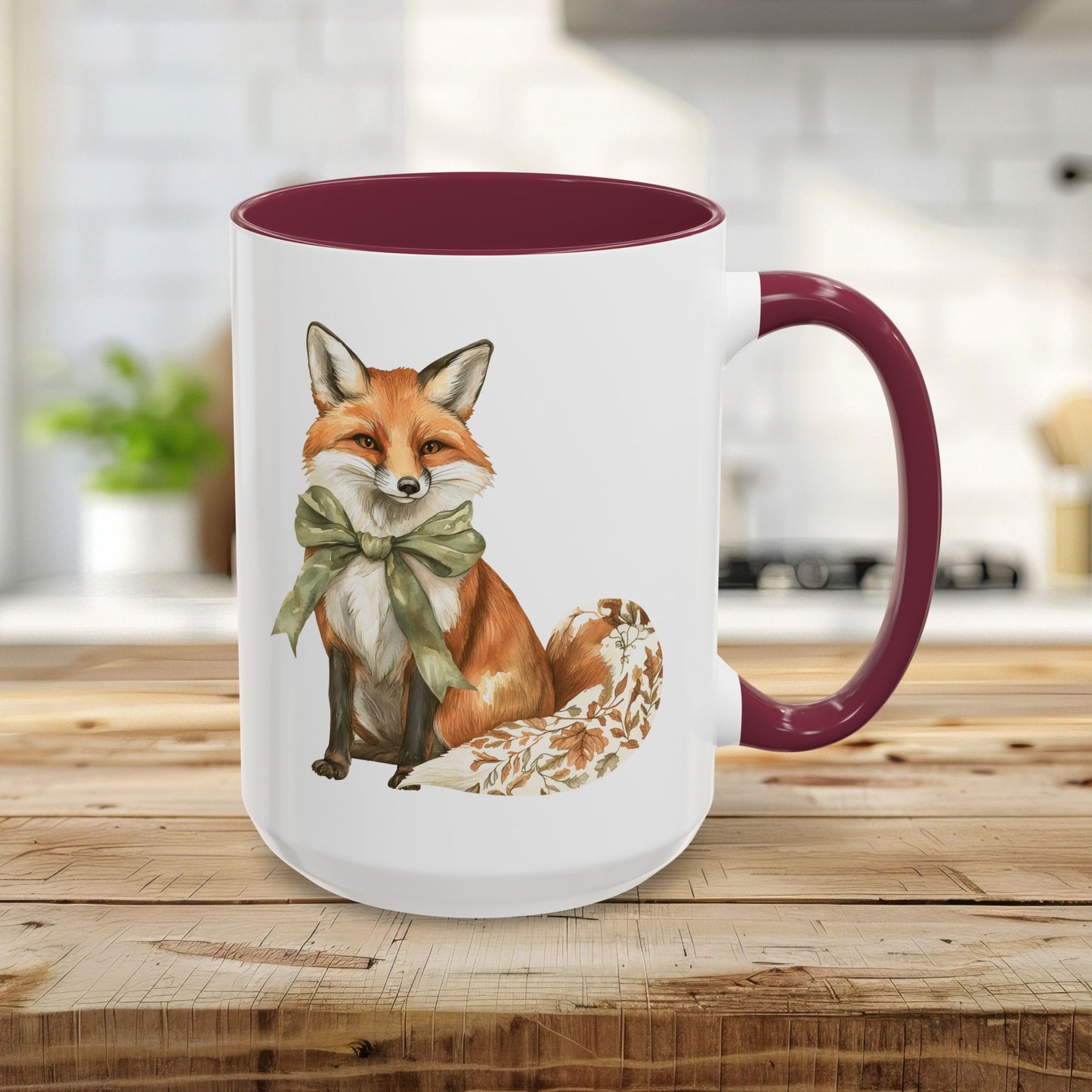 15oz white ceramic mug with a watercolor fox wearing a green bow and a maroon handle/interior.