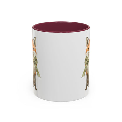 White ceramic mug with a watercolor fox wearing a green bow, featuring a burgundy interior and handle.