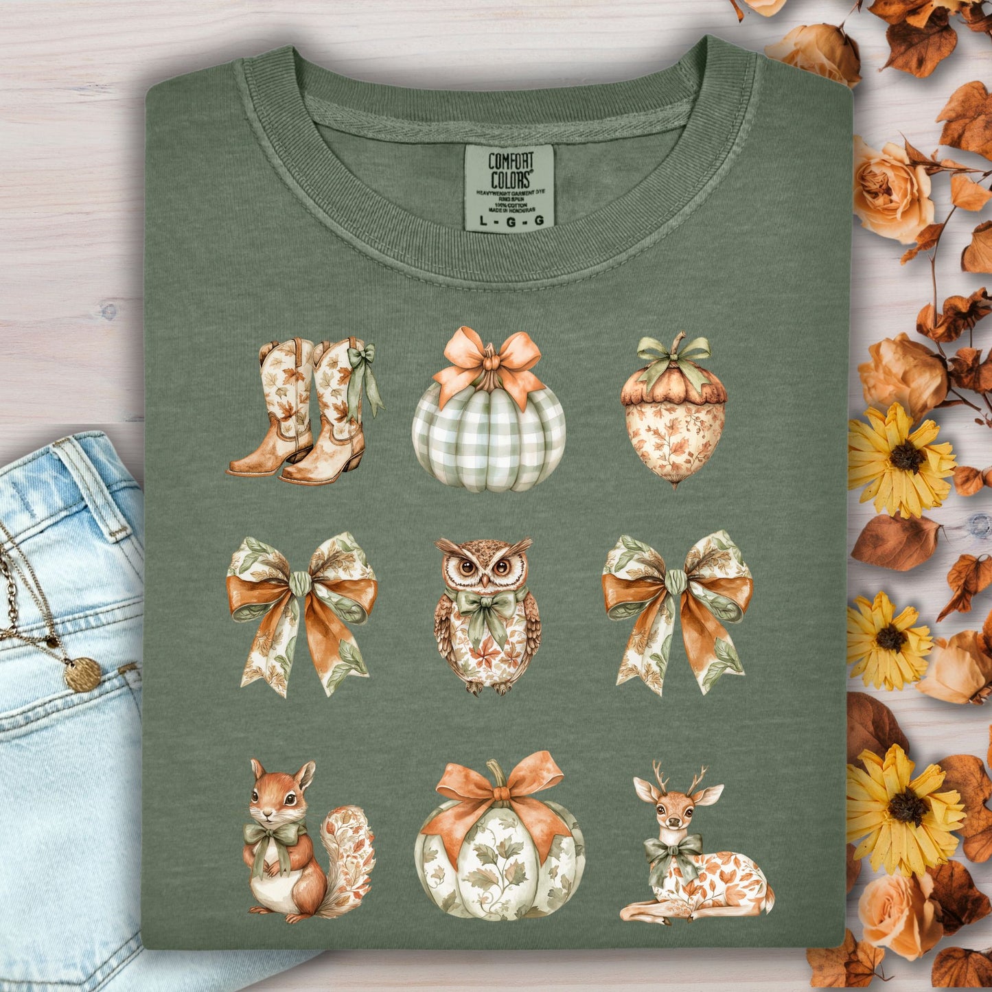 Moss green cotton t-shirt with boho fall artwork: bows, pumpkins, acorn, owl, squirrel, deer, and cowboy boots.