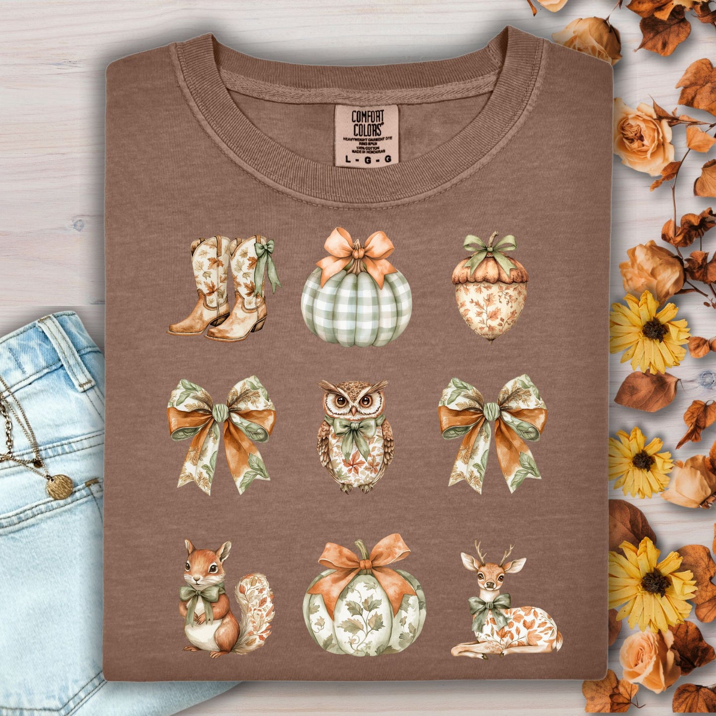Espresso cotton t-shirt with boho fall artwork: cowboy boots, pumpkins, bows, an owl, a squirrel, and a deer.