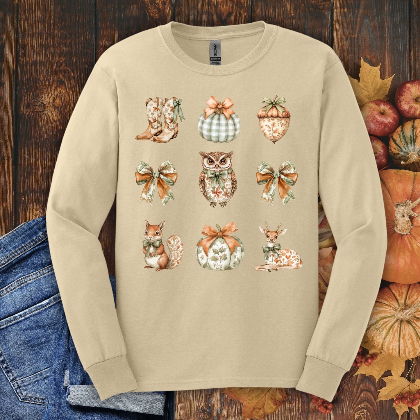 Sand long sleeve tee with fall cottagecore design: owl, boots, pumpkins, squirrel, deer, bows.