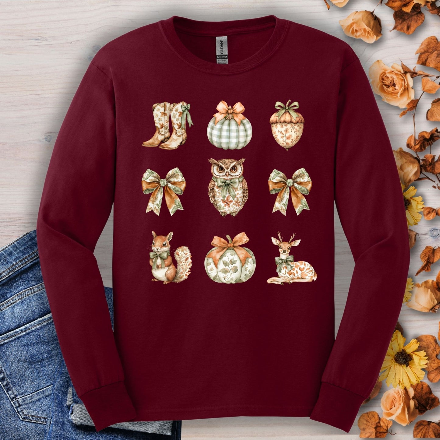 Maroon long sleeve tee with watercolor fall designs: owl, squirrel, deer, pumpkins, bows, boots, acorn.