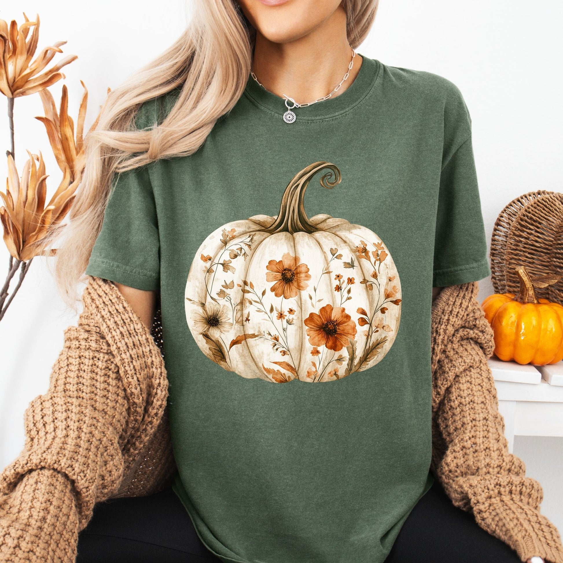 Garment-dyed, relaxed-fit green t-shirt with a white pumpkin blooming with orange and brown wildflowers.