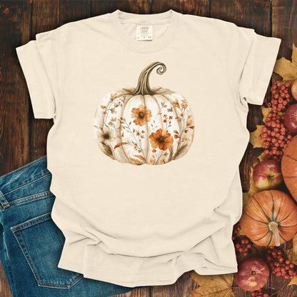 Ivory S-size garment-dyed t-shirt with a hand-painted white pumpkin blooming with warm, earthy wildflowers.