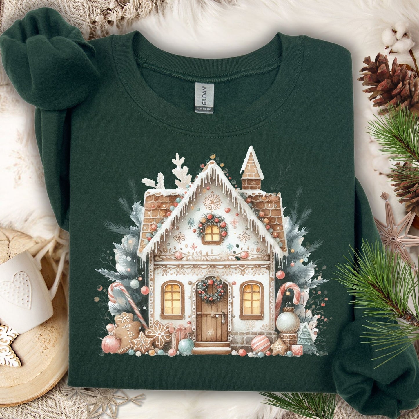 Forest Green Gildan sweatshirt with a watercolor boho gingerbread house design, surrounded by festive decor.