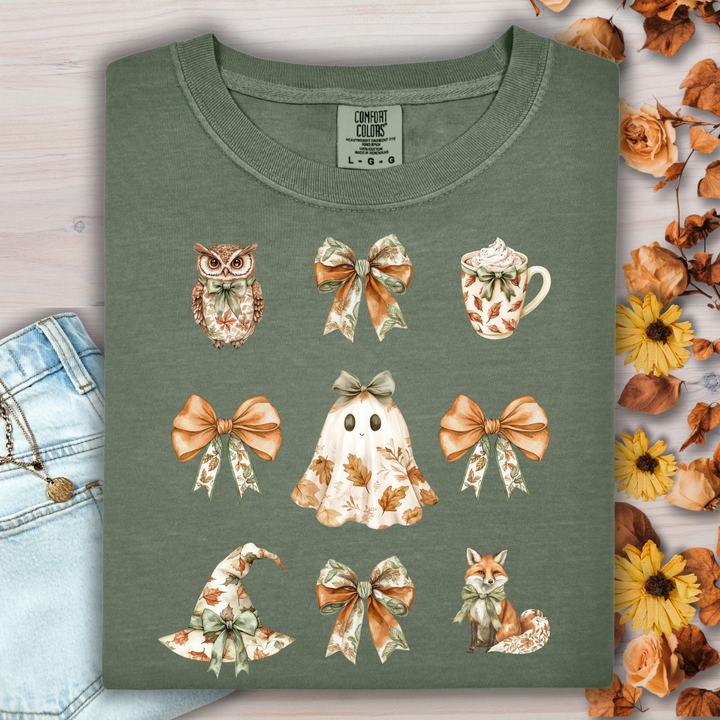 Moss green cotton t-shirt with boho Halloween art: owl, bows, latte, ghost, witch hat, and fox.
