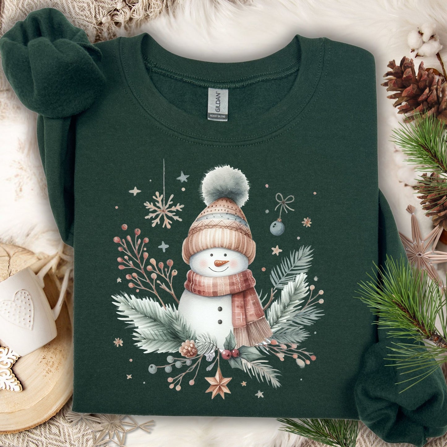 Forest Green S crewneck sweatshirt with a boho watercolor snowman, flannel scarf, and evergreen sprigs.