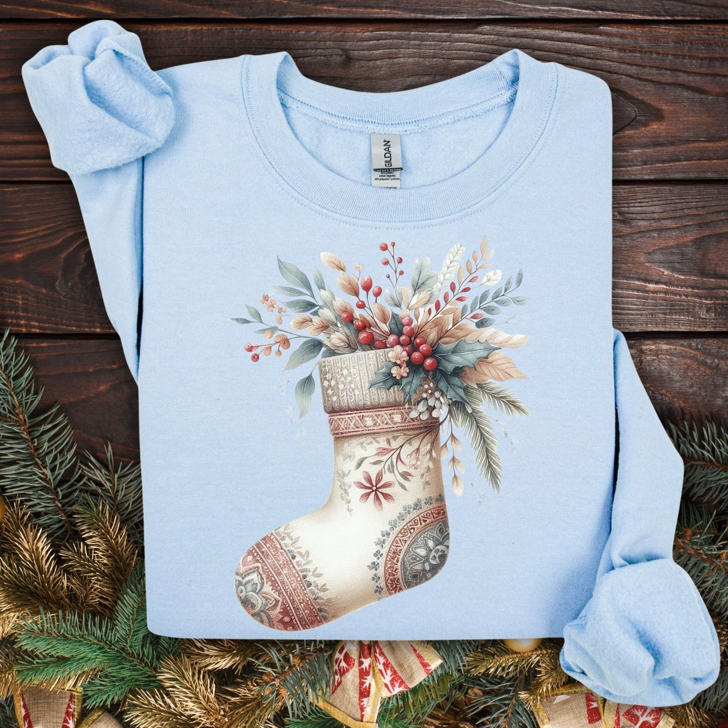 Light blue Gildan sweatshirt with a watercolor boho stocking design overflowing with greenery and berries.