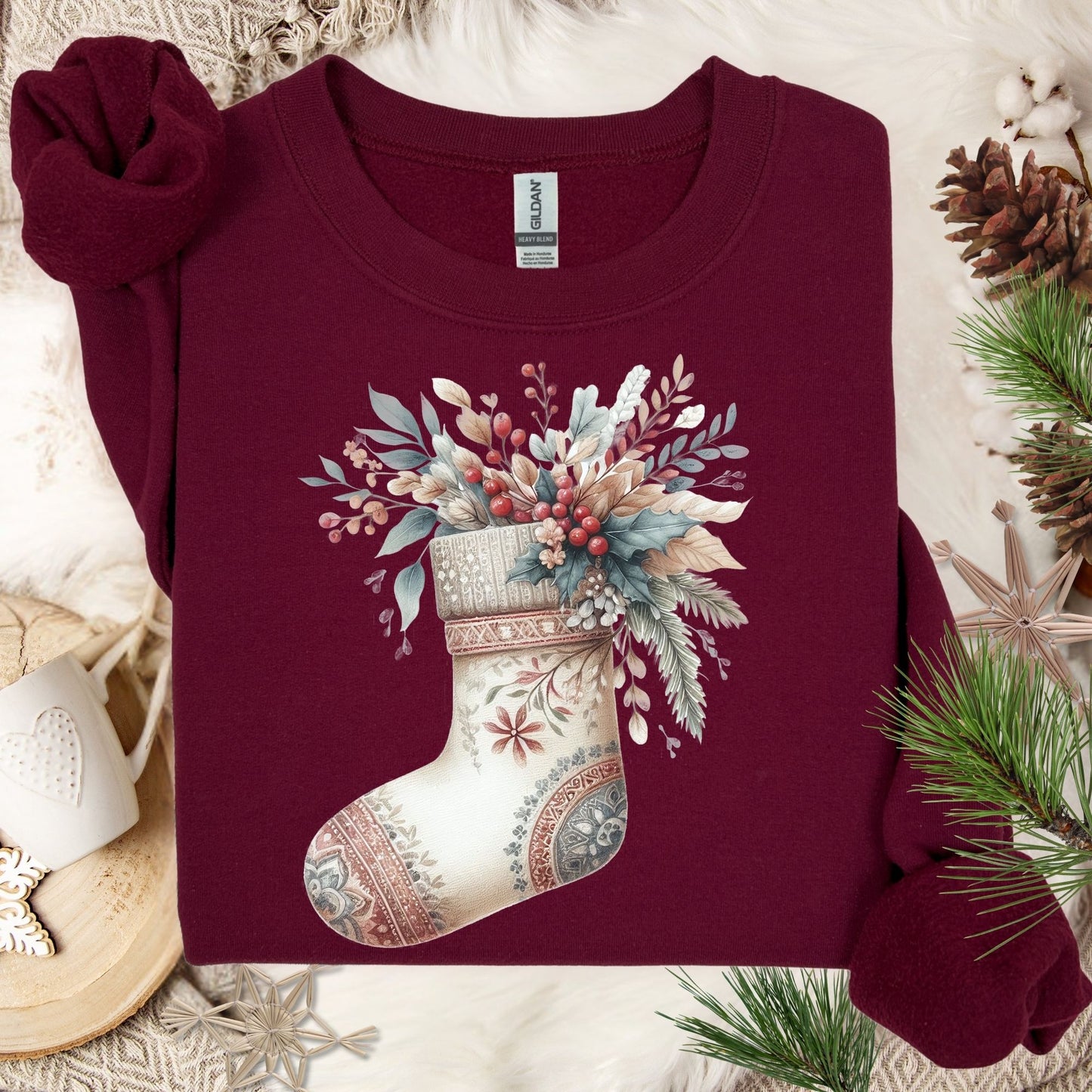Maroon Gildan sweatshirt with a watercolor boho stocking overflowing with muted seasonal greenery and berries.