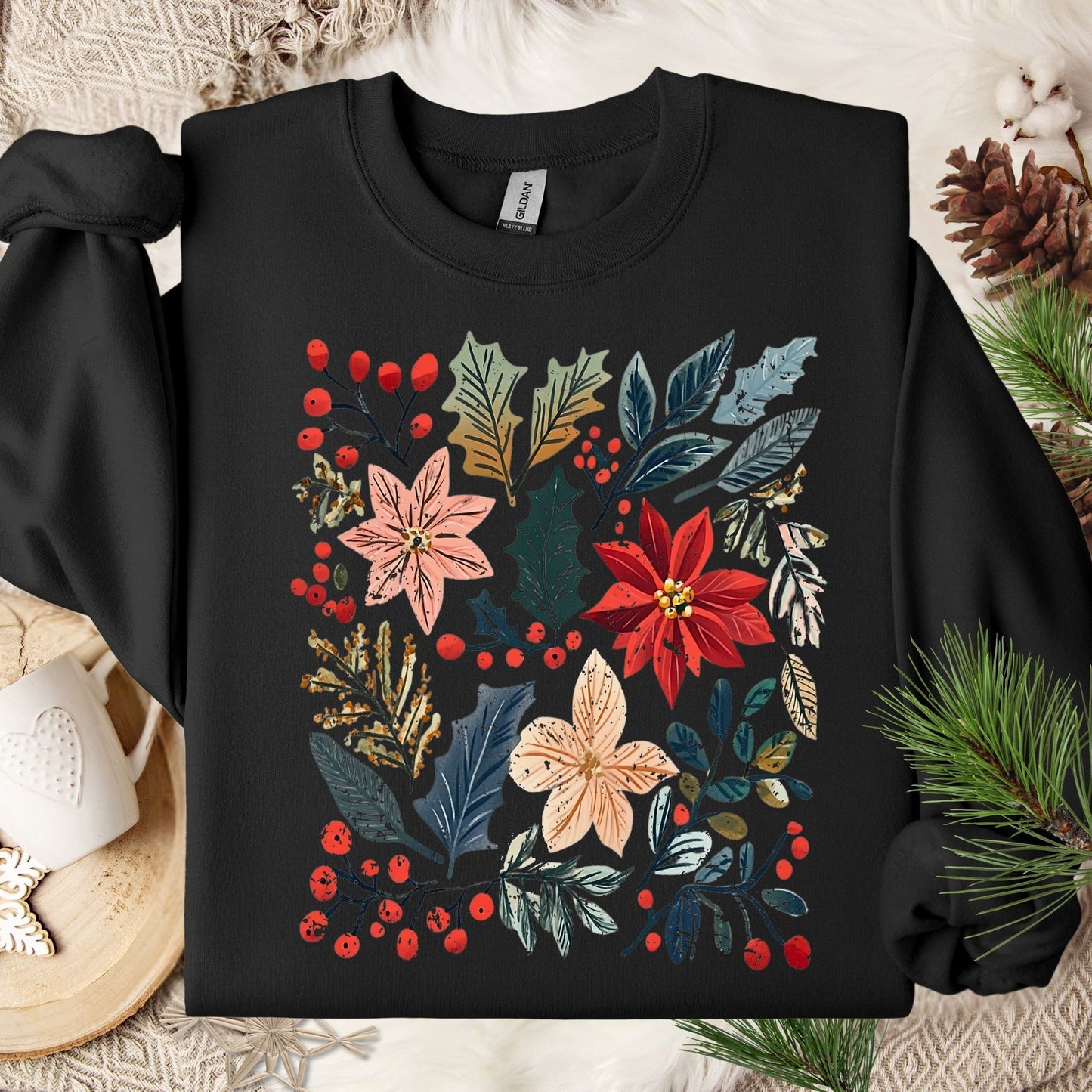 Black Gildan sweatshirt with vibrant boho poinsettia and floral design, surrounded by holiday decor.
