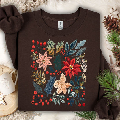 Dark chocolate Gildan sweatshirt with vibrant boho watercolor poinsettias, leaves, and berries, surrounded by festive decor.