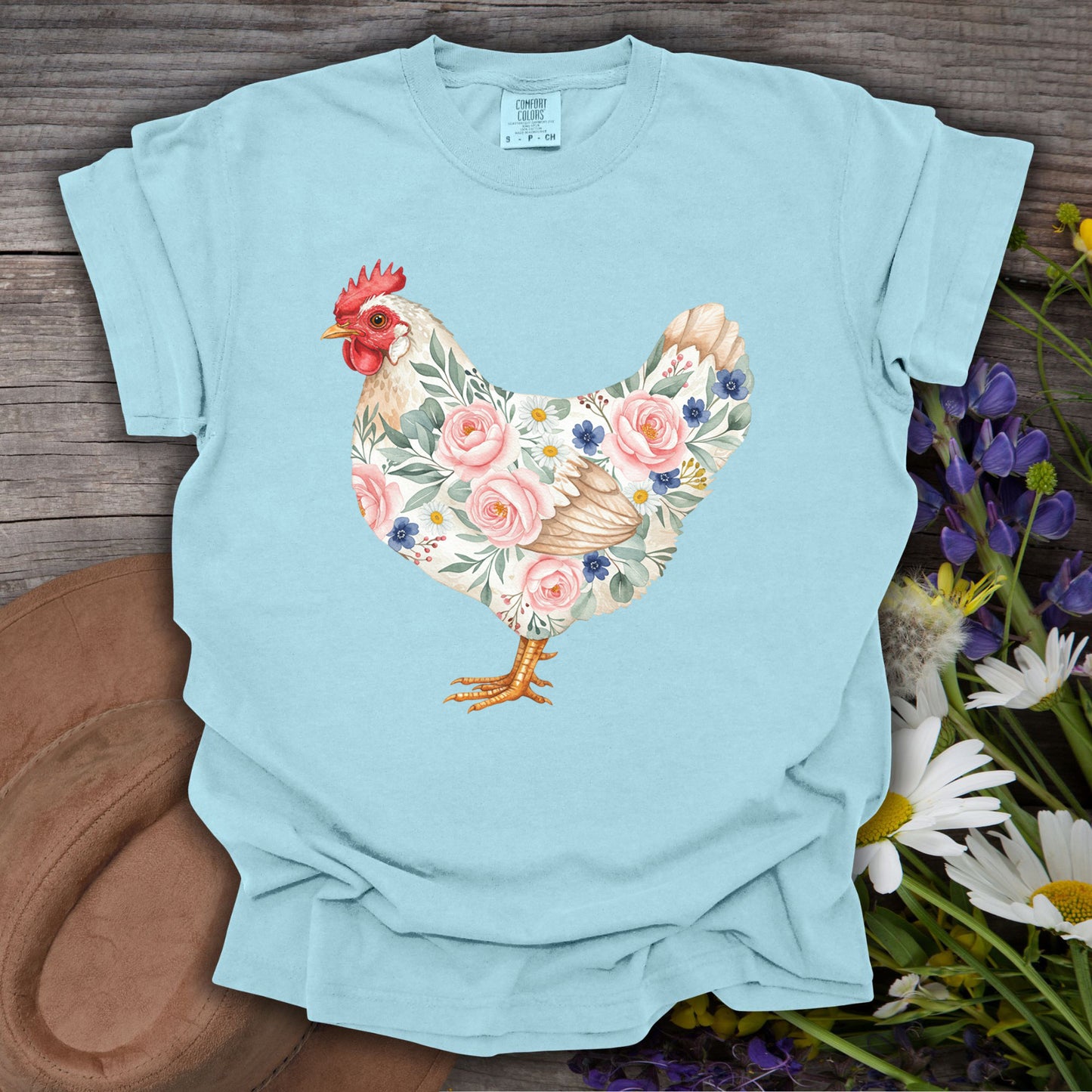 Chambray S t-shirt with a botanical chicken illustration featuring pink roses and blue flowers.