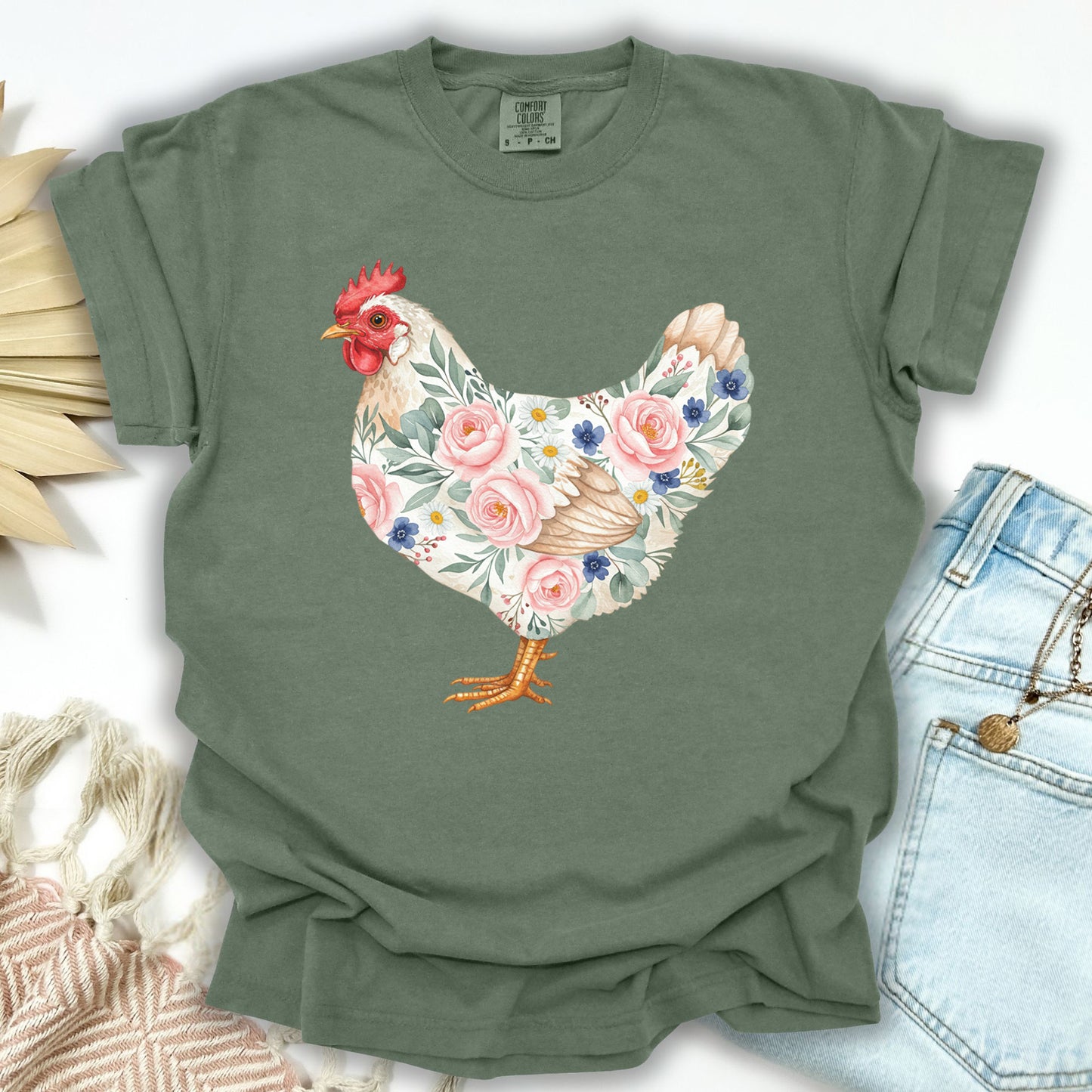 Moss S t-shirt with a botanical chicken illustration featuring pink roses and blue flowers.