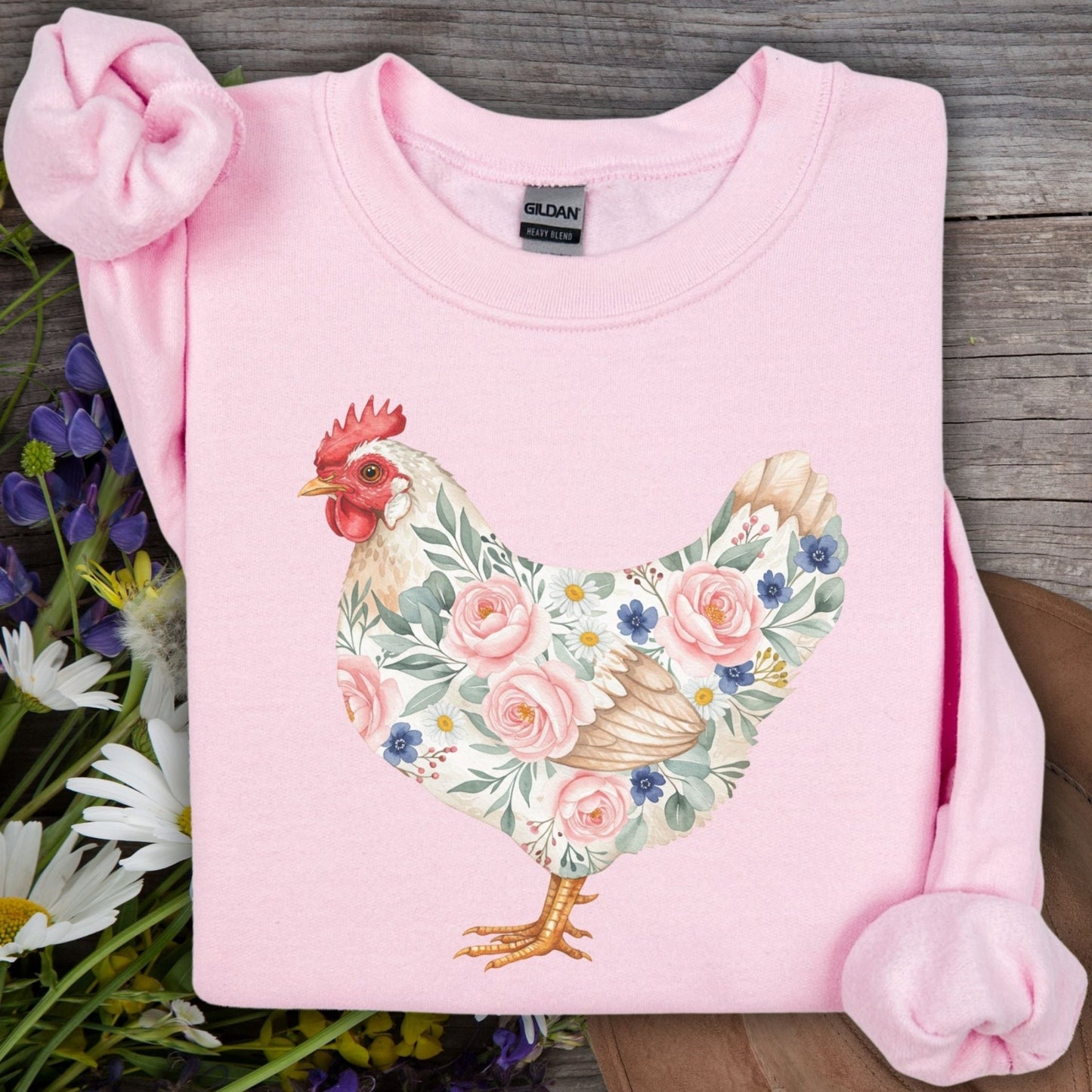 Light pink Gildan sweatshirt with a watercolor hen design adorned with roses, daisies, and forget-me-nots.