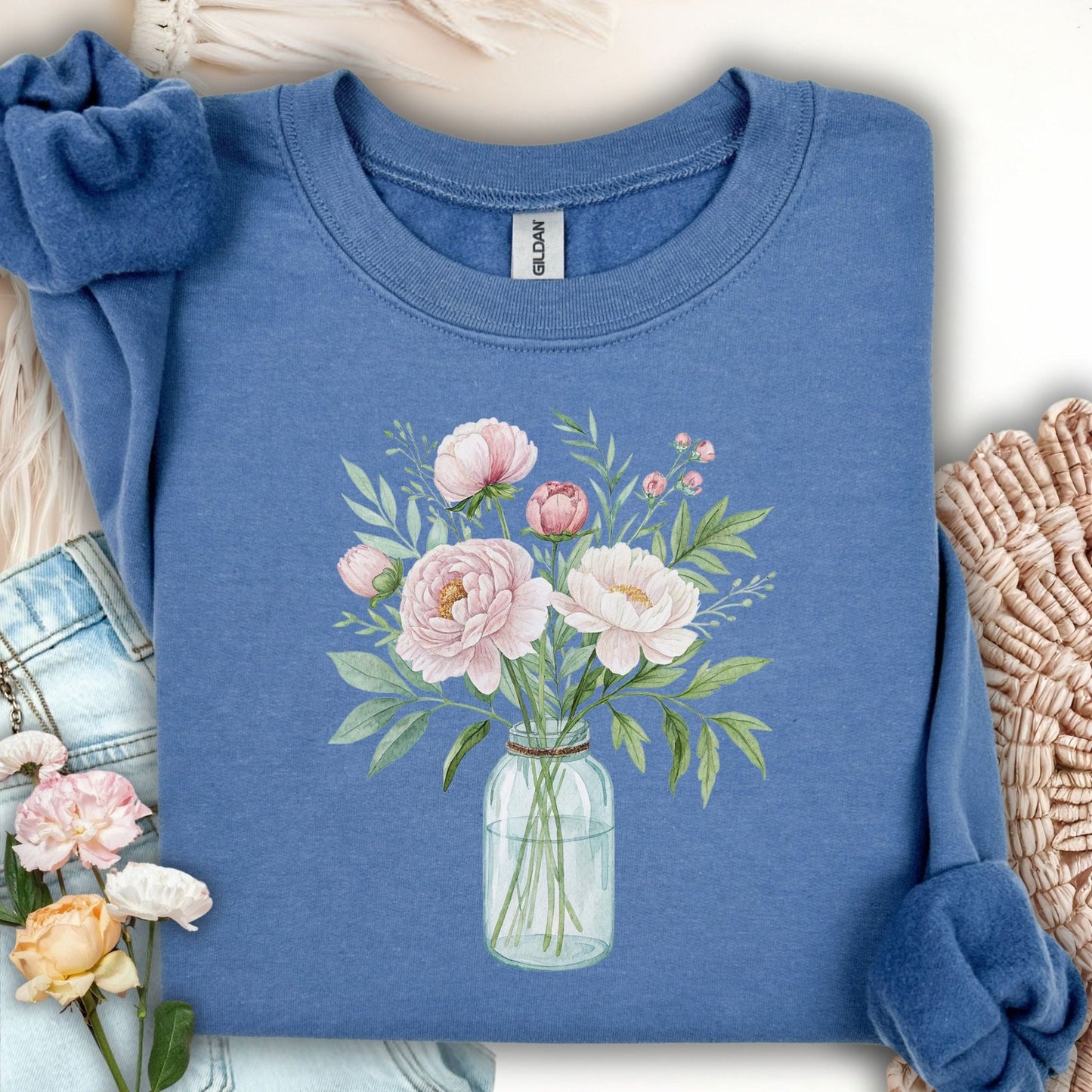Indigo blue sweatshirt with a botanical peony arrangement in a glass jar.