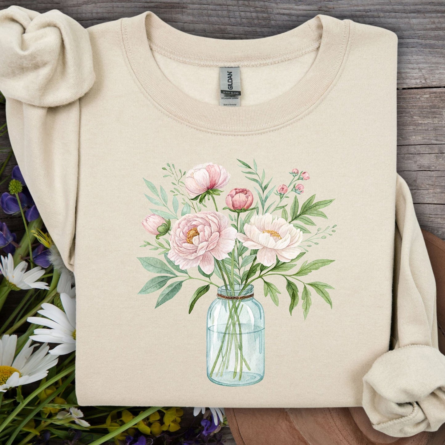 Sand sweatshirt with a botanical peony arrangement in a glass jar illustration.