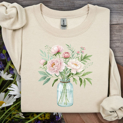 Sand sweatshirt with a botanical peony arrangement in a glass jar illustration.