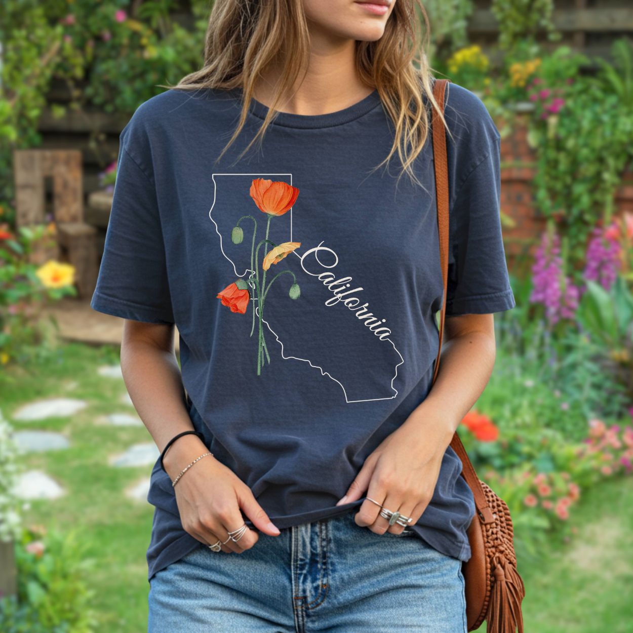 Garment-dyed navy cotton t-shirt with a white California outline and hand-drawn orange poppy design.