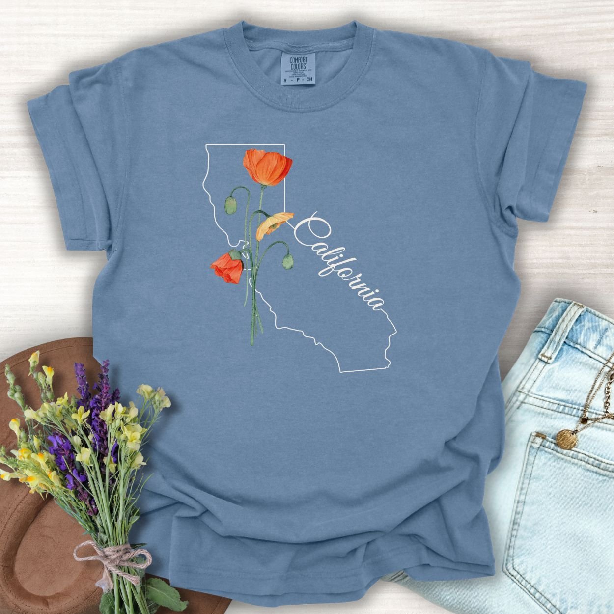 Blue Jean S-size garment-dyed cotton t-shirt with a white California outline and orange poppy design.