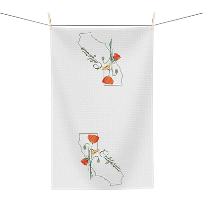 White microfiber tea towel with California outline and hand-drawn orange poppies, hanging on a clothesline.