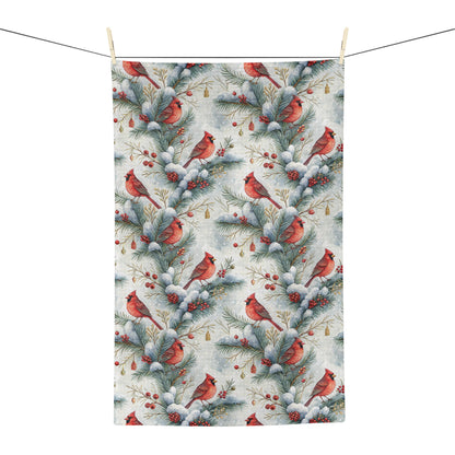 Microfiber tea towel with a repeating watercolor pattern of red cardinals on snowy pine branches and holly berries.