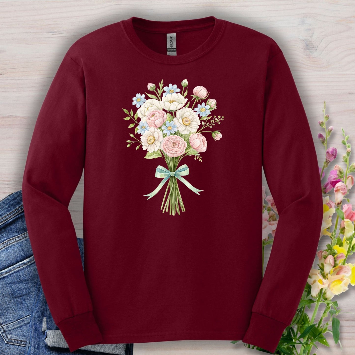 Maroon long-sleeve tee with a cheerful botanical bouquet of dahlias, daisies, ranunculus, and roses.