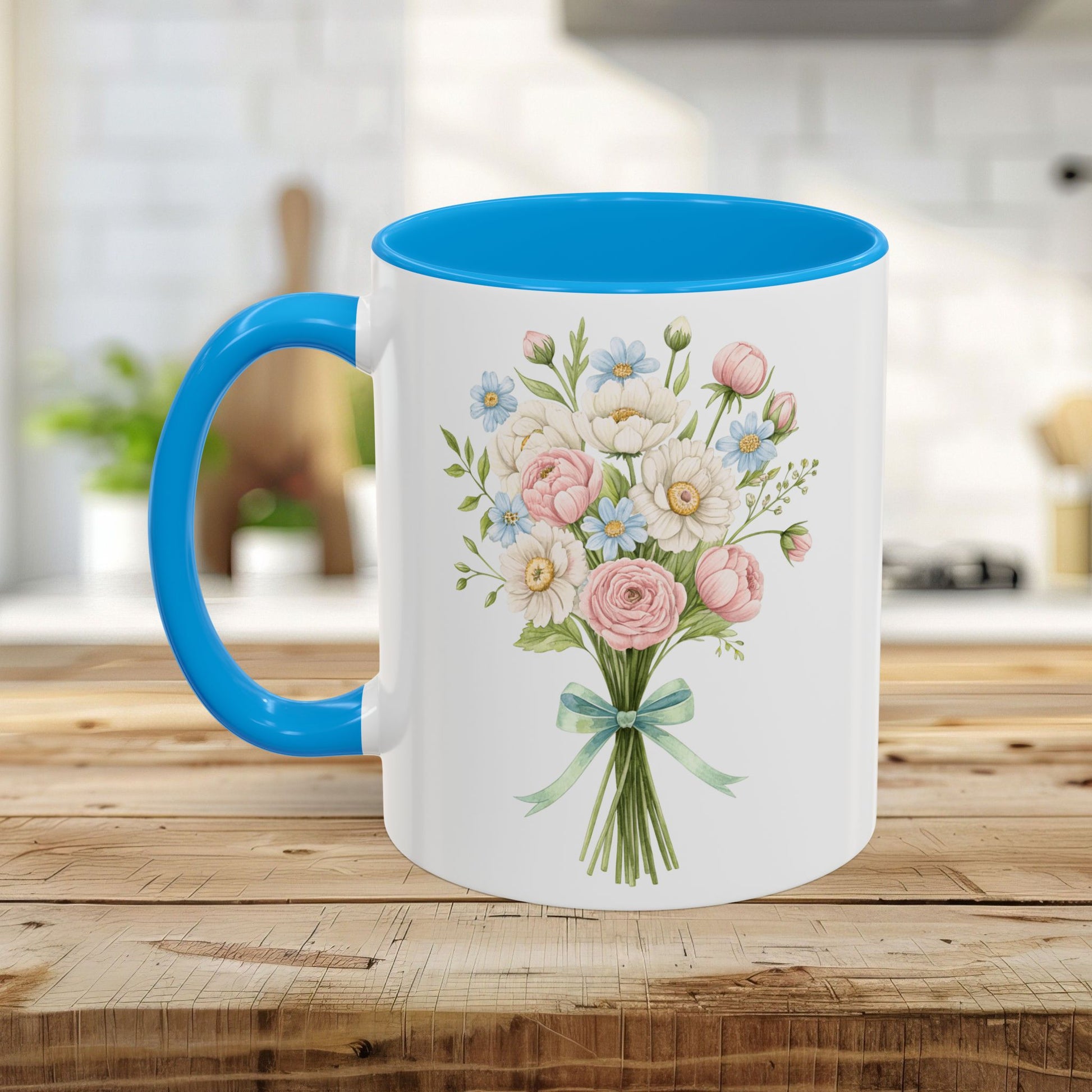 White ceramic mug with a pastel floral bouquet, blue interior, and C-shaped blue handle on a wooden surface.