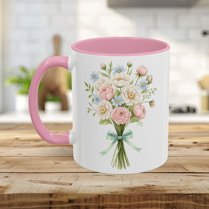 White ceramic mug with pink handle and interior, featuring a watercolor bouquet of pastel roses and daisies.