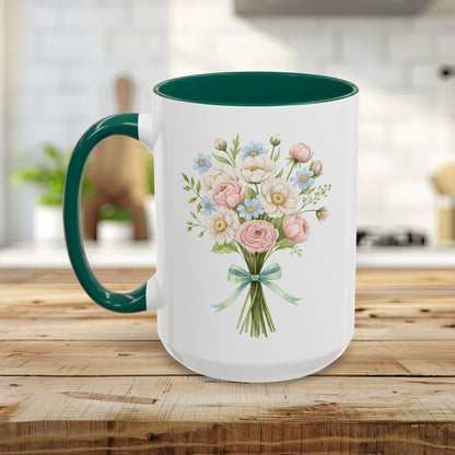 White ceramic mug with a green handle and interior, featuring a watercolor floral bouquet of pastel roses and daisies.