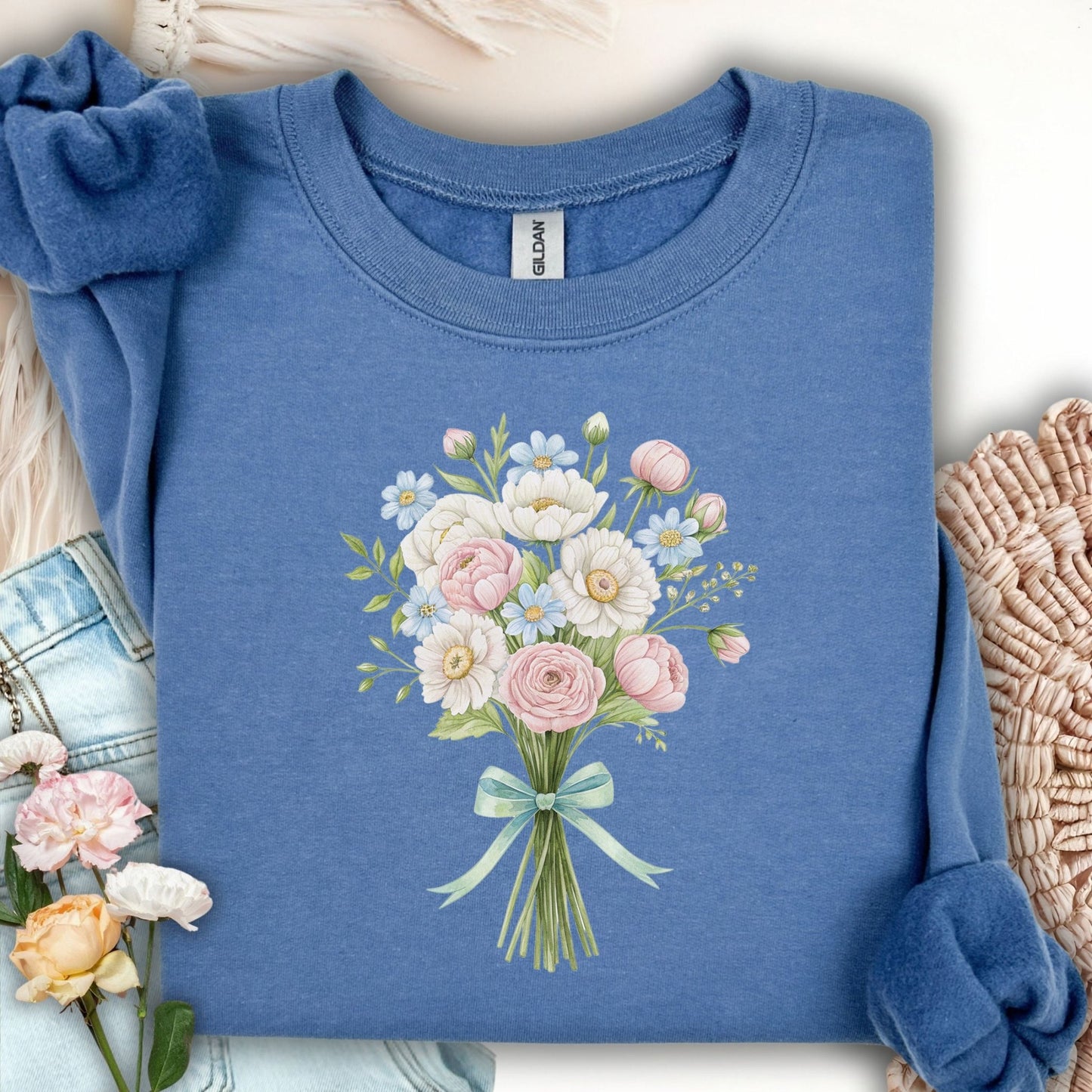 Indigo Blue sweatshirt with a pastel floral bouquet of peonies, dahlias, ranunculus, and daisies tied with a ribbon.