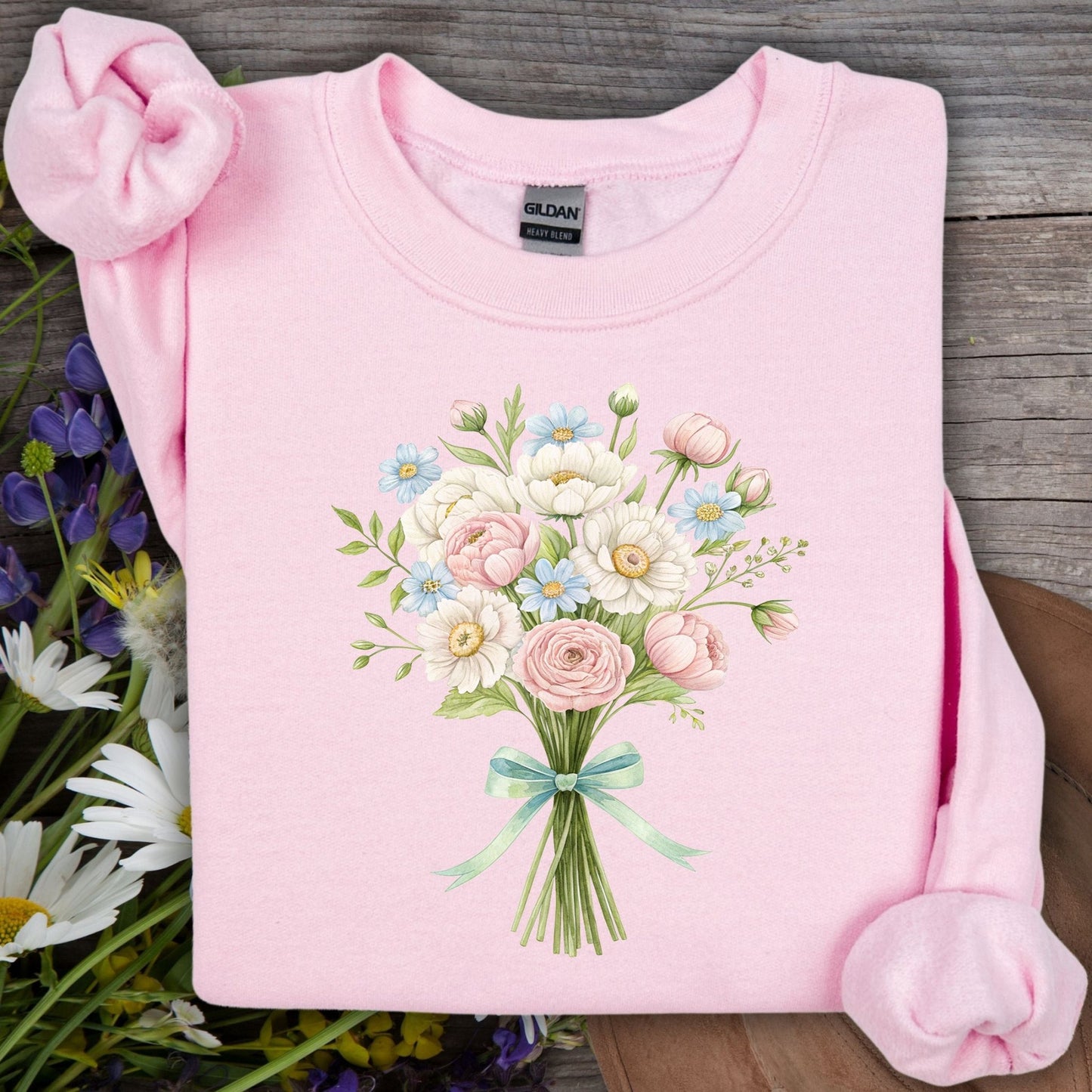 Light pink sweatshirt with a watercolor bouquet of peonies, dahlias, ranunculus, and daisies tied with a mint ribbon.