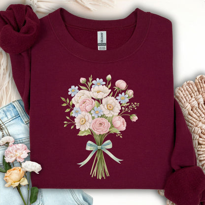 Maroon sweatshirt with a watercolor bouquet of pink, white, and blue flowers tied with a light blue ribbon.